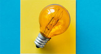 Immagine di Light bulb against yellow square background