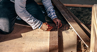 Immagine di Man measuring boards of wood